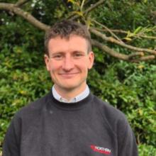 George Coiley in front of greenery 