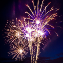 Image shows colourful fireworks illuminating the evening sky