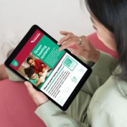 Image of person with tablet reading free Northern Powergrid advice on low carbon technology for your home.