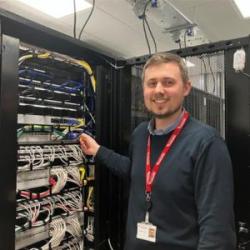 Tom Skeet stood in front of a computer server